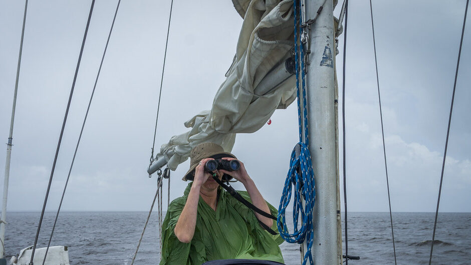 Boater using binoculars in wet conditions under falling rain