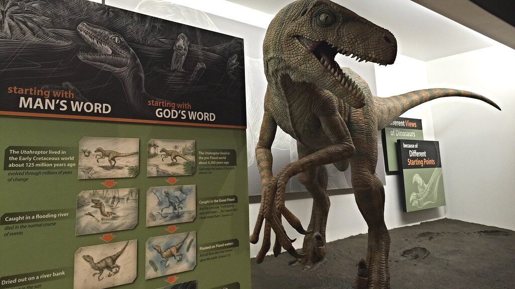 Life-size Utahraptor model hunting prey on exhibit at the Creation Museum