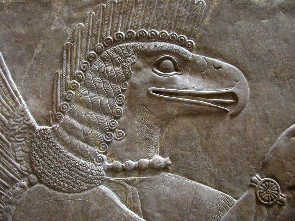 A detailed ancient carving depicts a mythical bird with a strong beak and feathered head.