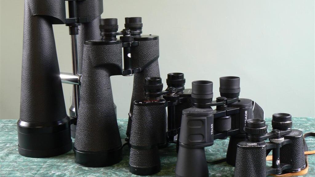 Different types and sizes of binoculars lined up for comparison