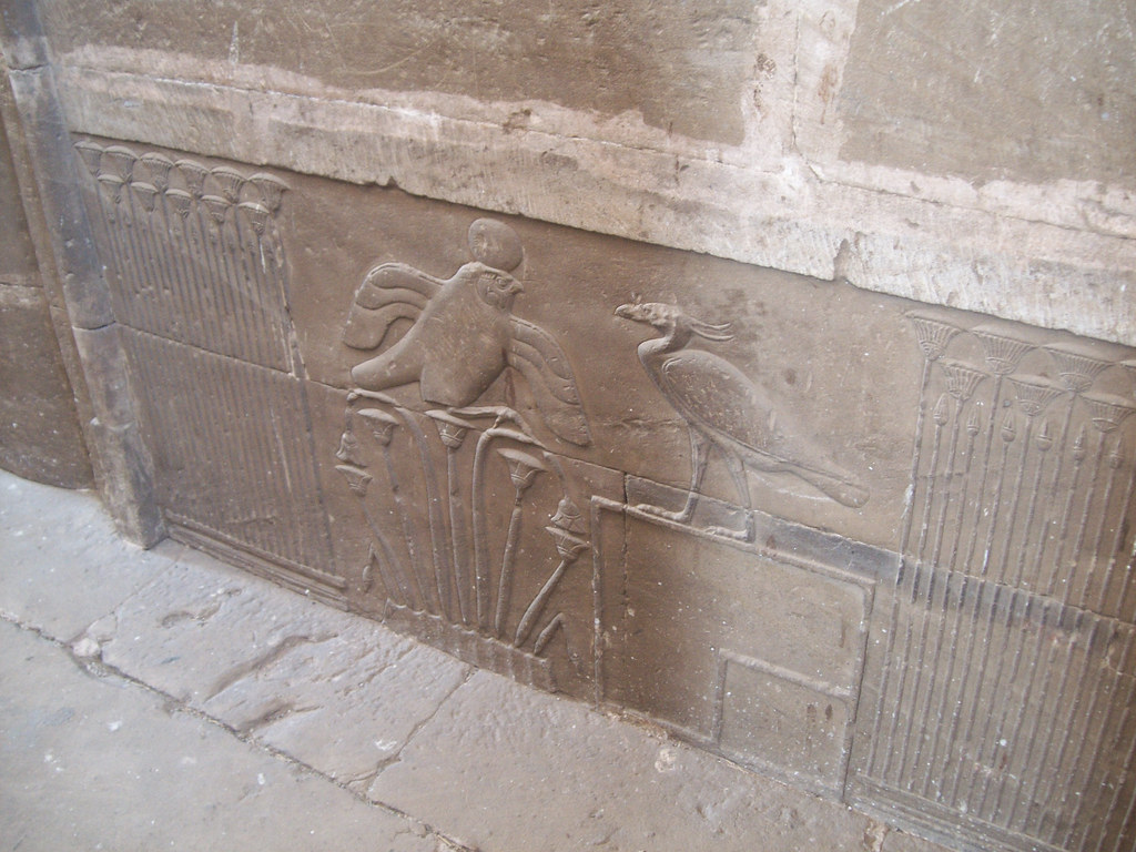 An ancient stone carving depicts two birds with detailed wings and feathers.