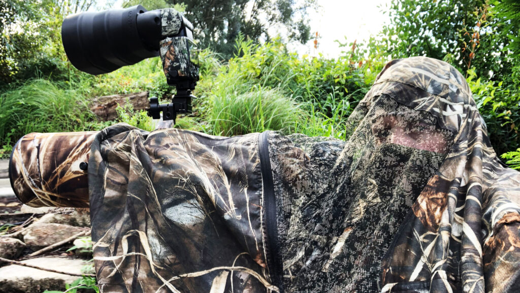 Wildlife photographer wearing camouflage gear