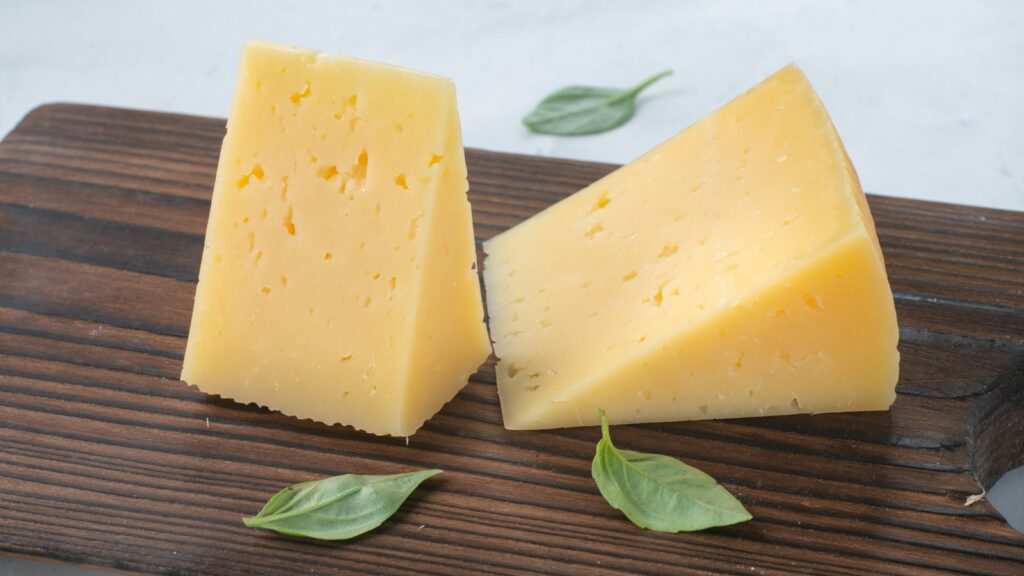 Two slices of cheese on a wooden board