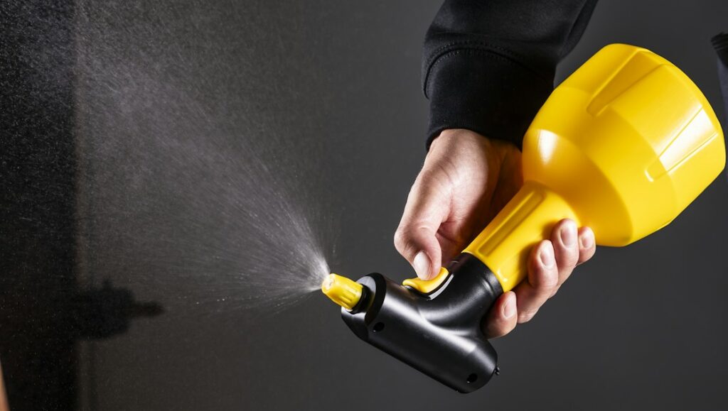 Person using handheld sprayer