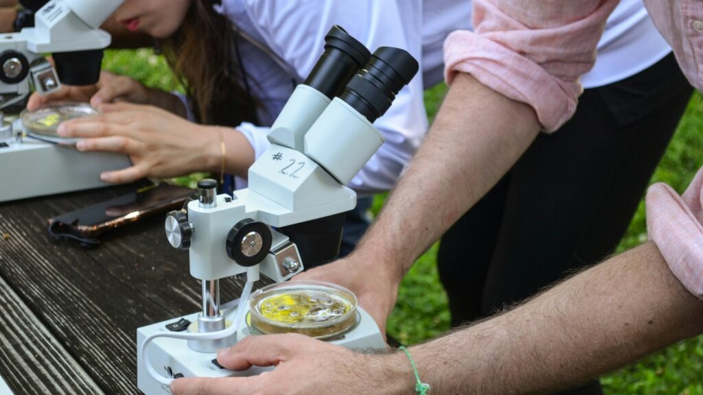 Team of researchers analyzing samples through microscopes