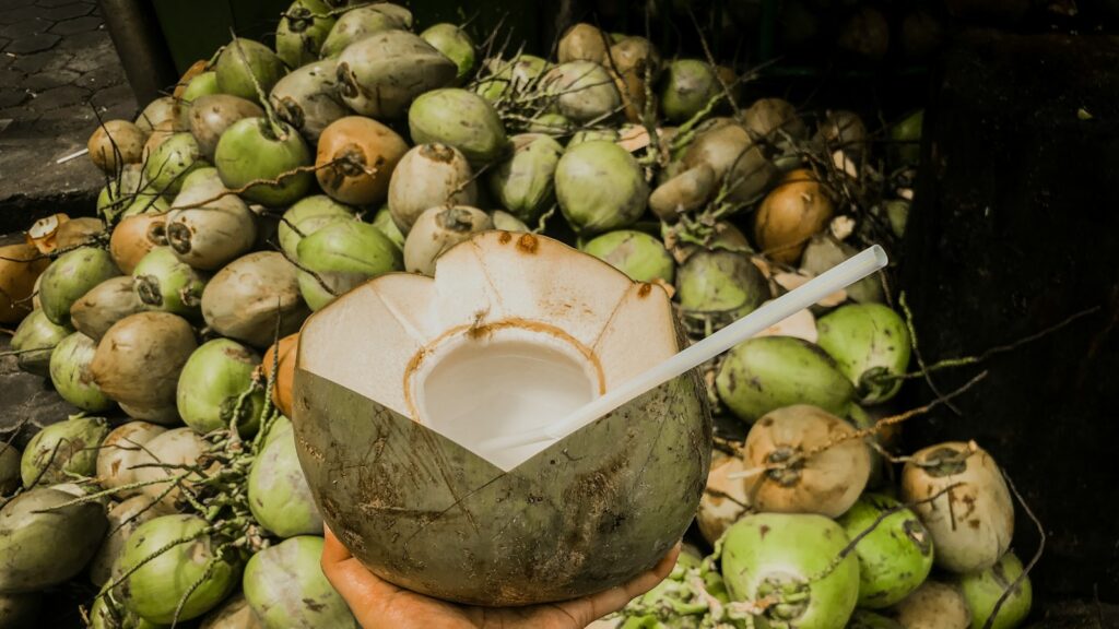 Hand holding a freshly opened coconut