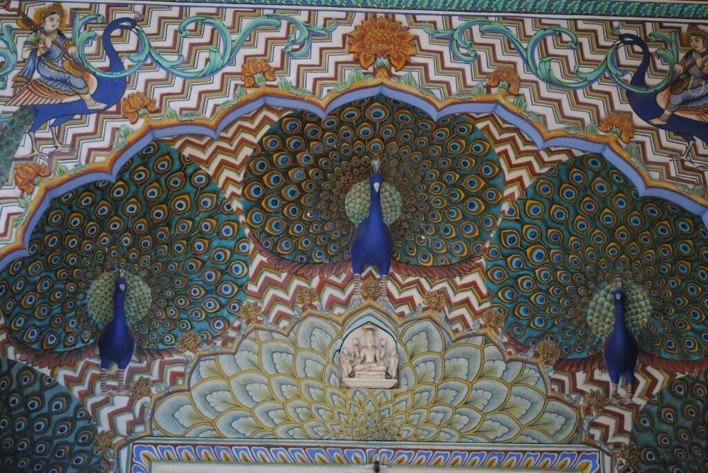 An ornate archway is decorated with colorful painted peacocks and intricate patterns.