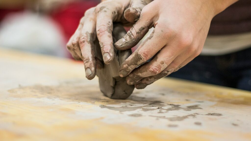 Potter using hands to shape wet clay