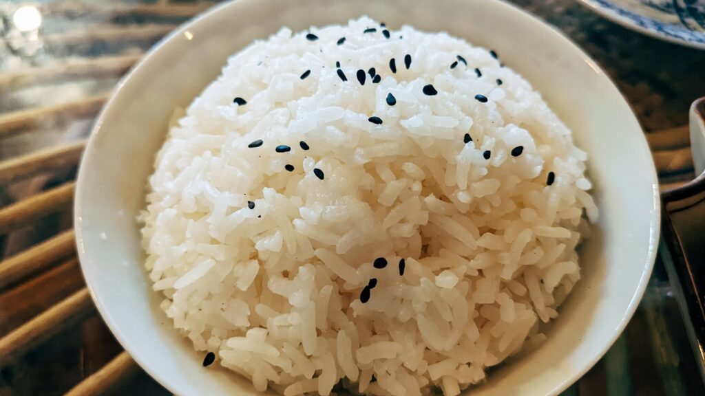 Bowl of plain white rice topped with sesame seeds