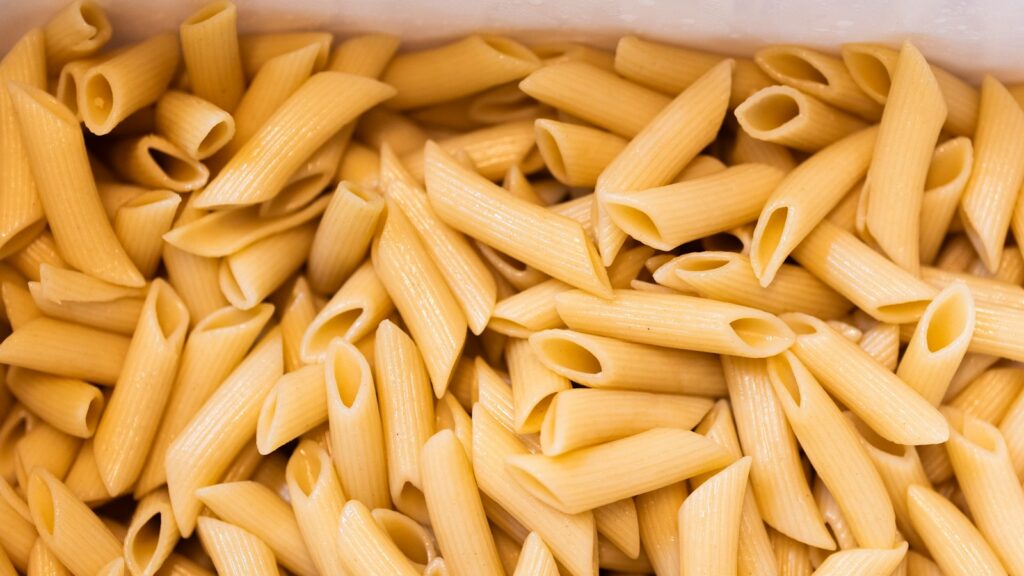 Container filled with cooked penne pasta